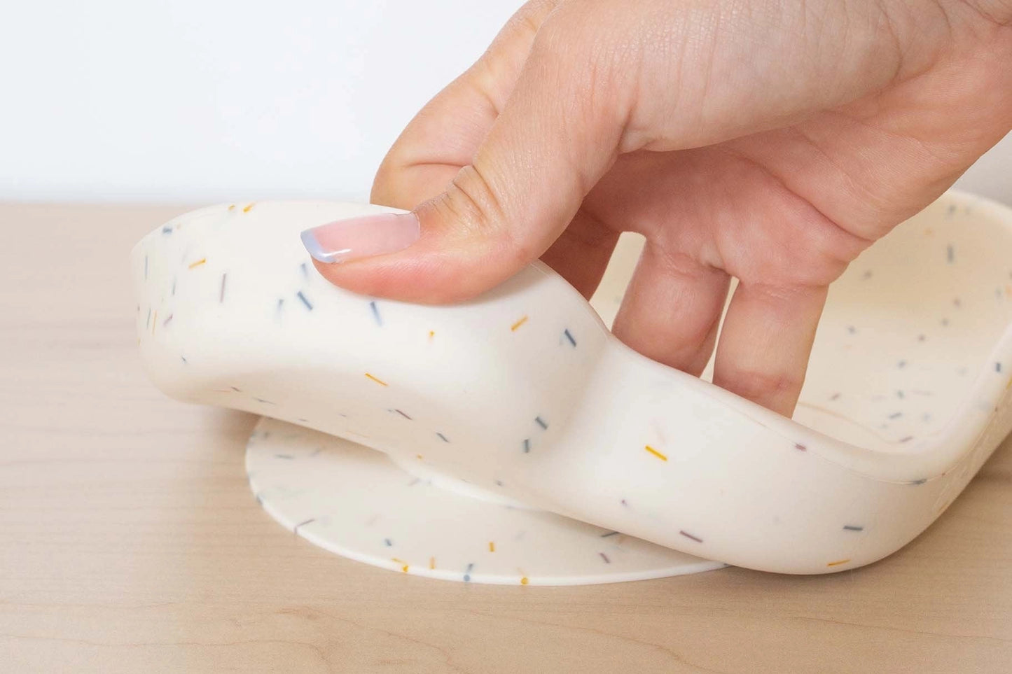 The Cotton Cloud silikoninė lėkštė su siurbtuku su lengvai kilnojama kraštine ant lygaus paviršiaus.