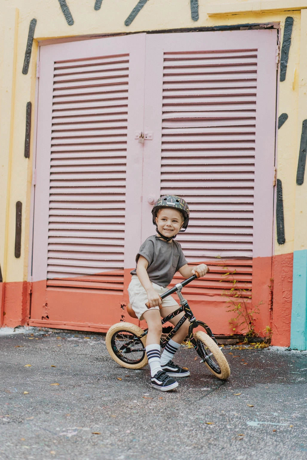 Vaikas važiuoja ant Banwood X Marest balansinis dviratis, dėvintis šalmą ir sportinę aprangą