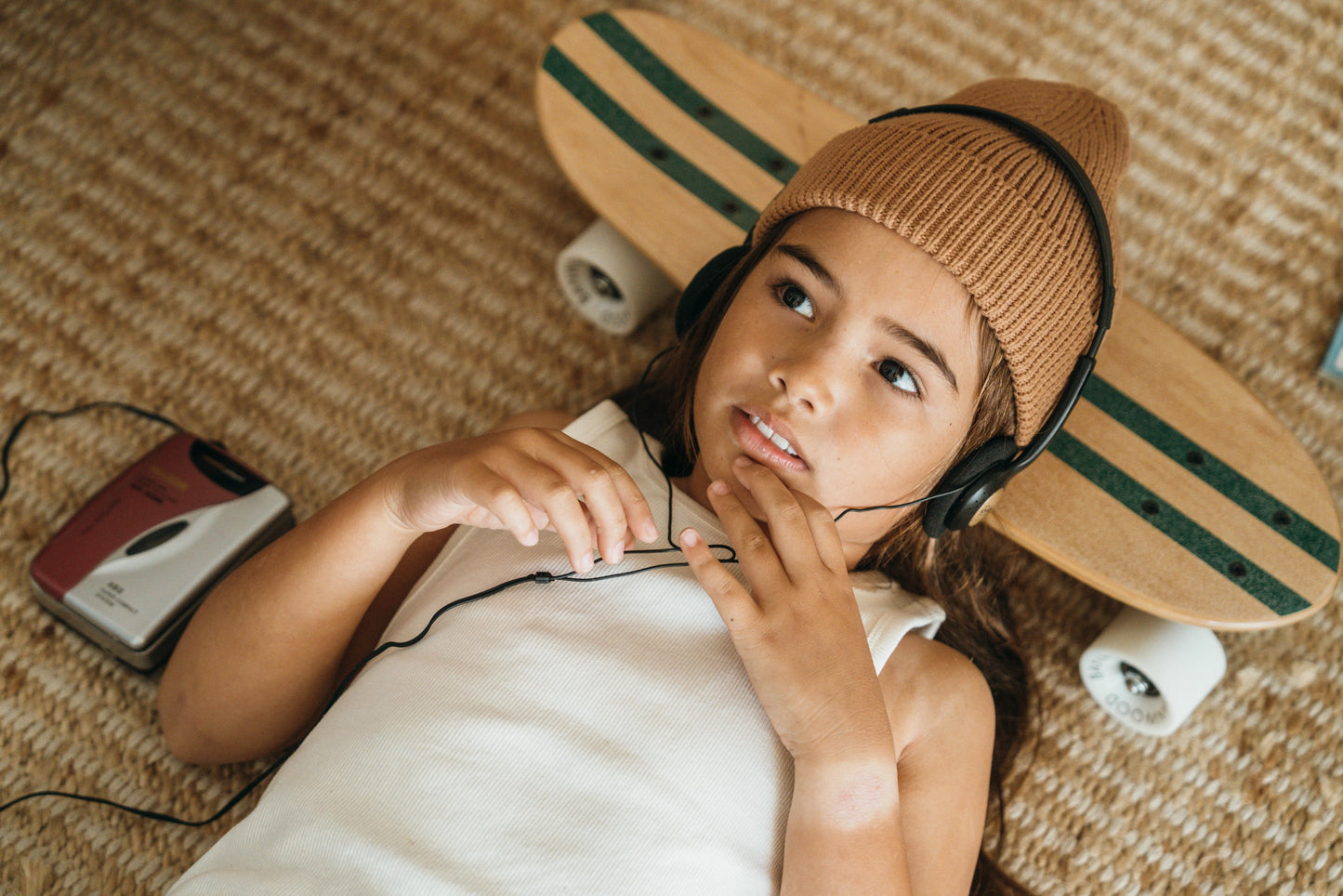 Banwood vaikiška riedlentė, klausydamasi muzikos su ausinėmis.